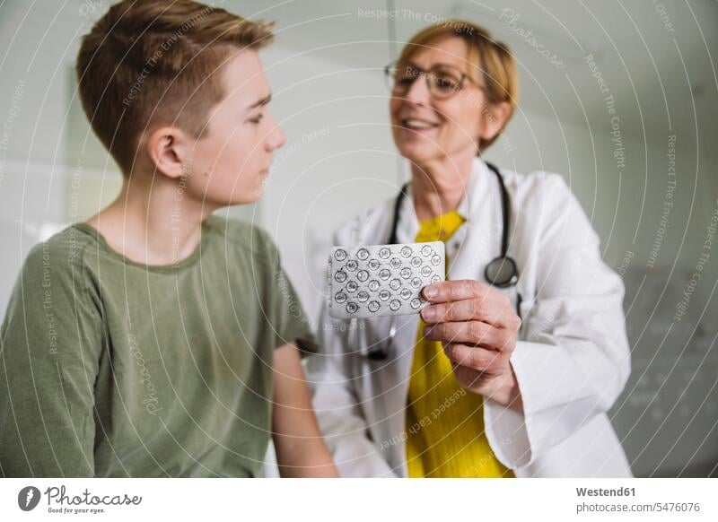 Doctor explaining medication to teenage boy in medical practice health healthcare Healthcare And Medicines medicine disease diseases ill illnesses sick Sickness