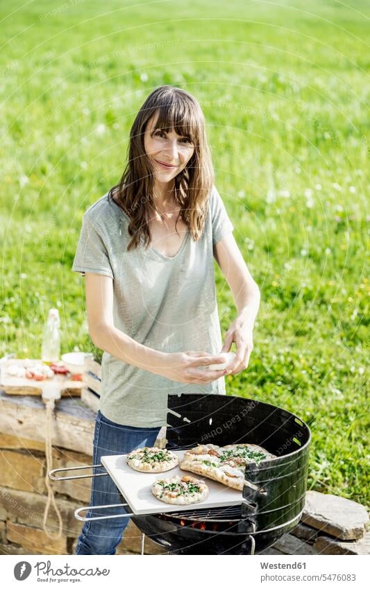 Portrait of smiling woman preparing food on barbecue grill human human being human beings humans person persons caucasian appearance caucasian ethnicity