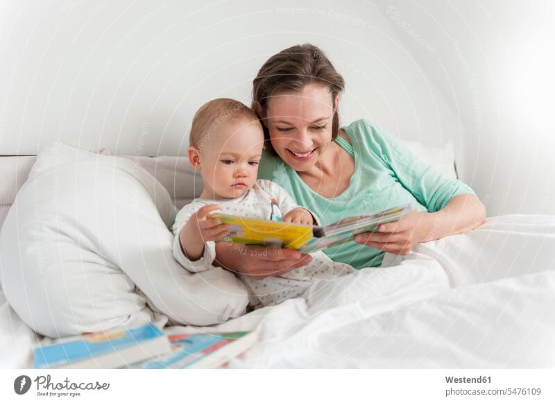 Mother and baby in bed reading picture book infants nurselings babies Picture Books picture-books home at home mother mommy mothers ma mummy mama beds people