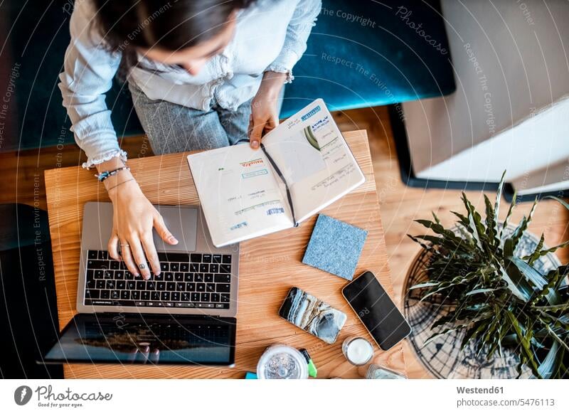 Young woman logging on to laptop, top view human human being human beings humans person persons adult grown-up grown-ups grownup grownups young young adult