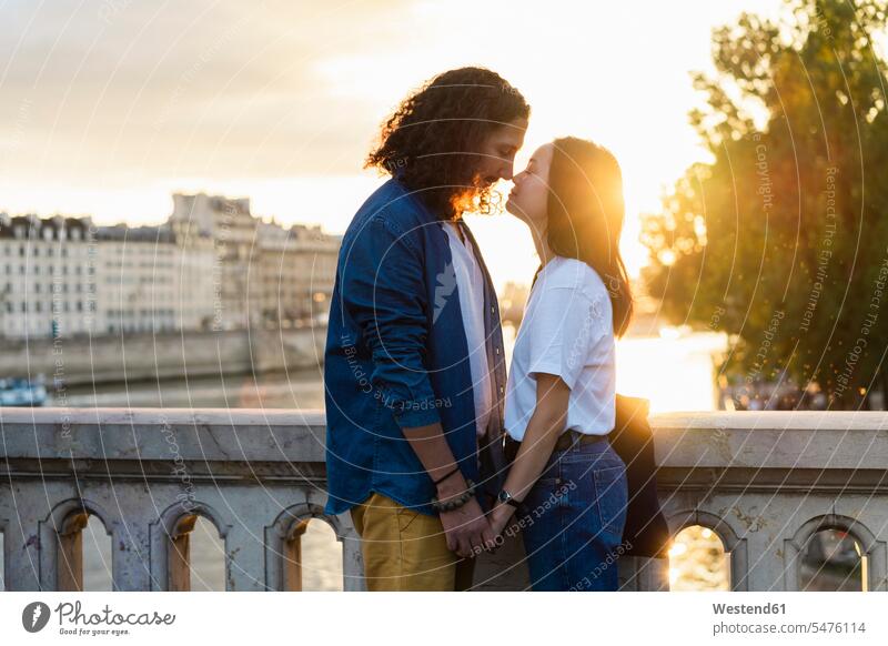 France, Paris, affectionate young couple at river Seine at sunset Affection Affectionate sunsets sundown twosomes partnership couples River Rivers atmosphere