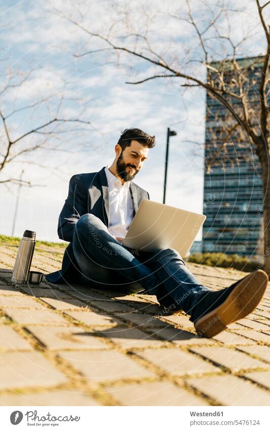 Businessman using laptop outside office building office buildings Laptop Computers laptops notebook Business man Businessmen Business men built structure