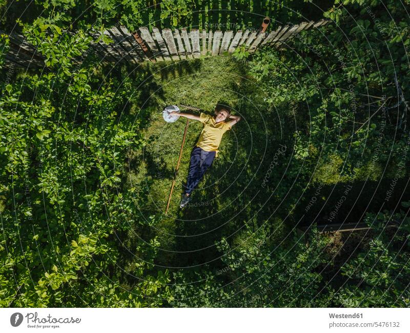 Aerial view of mid adult woman resting on grassy land in yard color image colour image leisure activity leisure activities free time leisure time