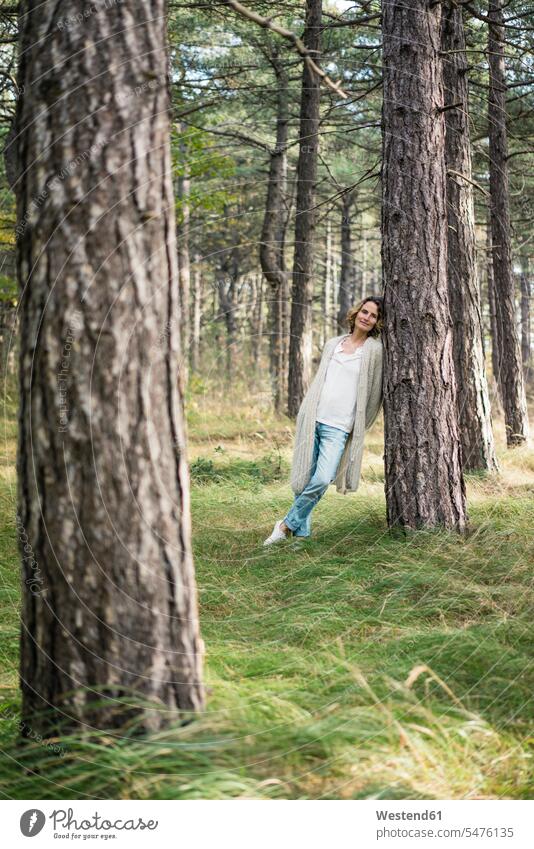 Serene woman standing in the forest relaxation relaxing Tree Trunk Tree Trunks getting away from it all Getting Away From All unwinding woods forests