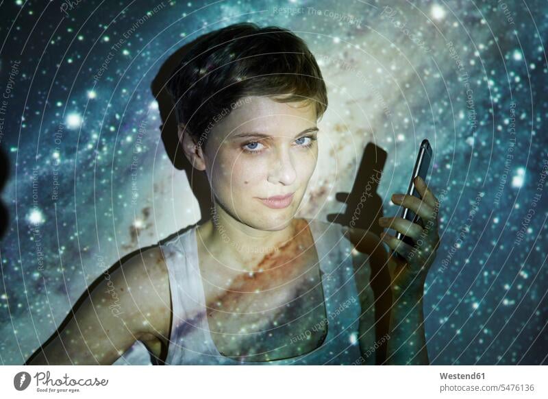 Portrait of woman, holding smartphone, projection of starry sky Milky Way females women looking at camera looking to camera looking at the camera Eye Contact