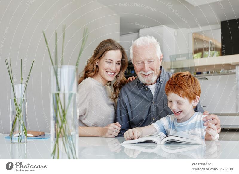 Happy grandfather, mother and son reading book in a villa generation books Tables smile delight enjoyment Pleasant pleasure Cheerfulness exhilaration gaiety gay