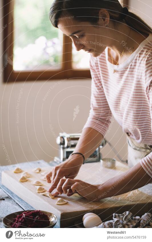 Woman preparing ravioli, beetroot sage filling woman females women Pasta Dough dough preparation prepare pressing pushing stuffing Ravioli Adults grown-ups