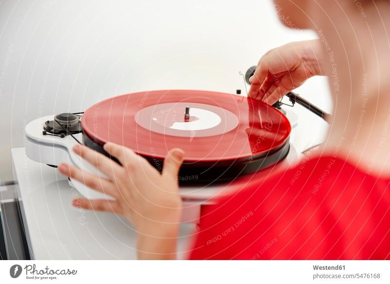 Woman putting red vinyl record on record player placing place turntable records woman females women colour colours analogue Media Adults grown-ups grownups