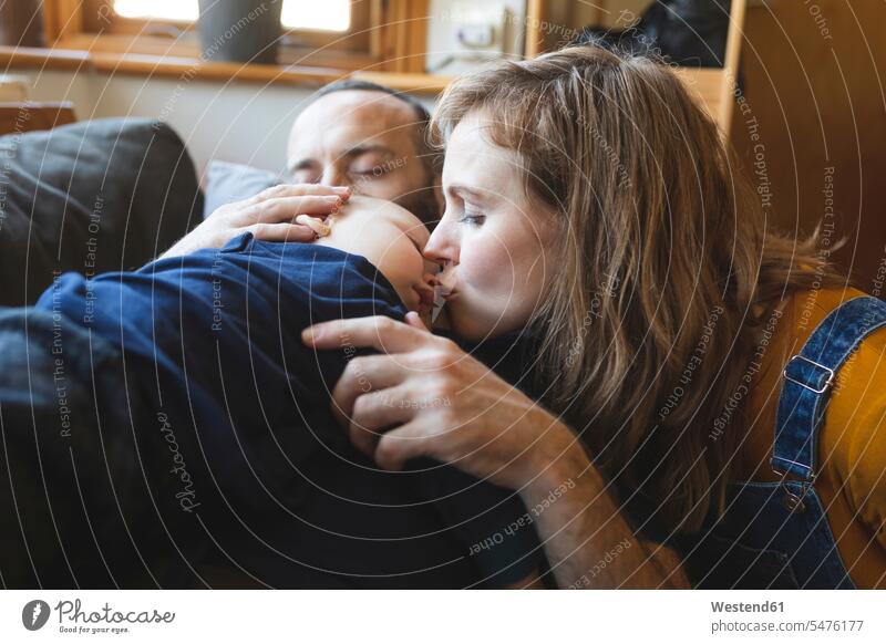 Affectionate family on the sofa with sleeping little son human human being human beings humans person persons caucasian appearance caucasian ethnicity european