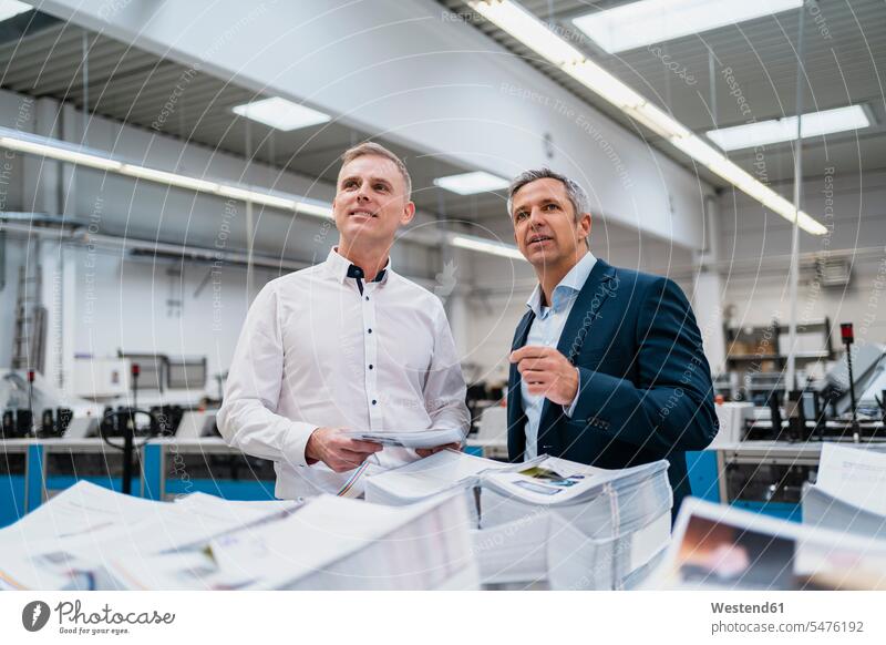 Two businessmen talking in a factory business life business world business person businesspeople associate associates business associate business associates