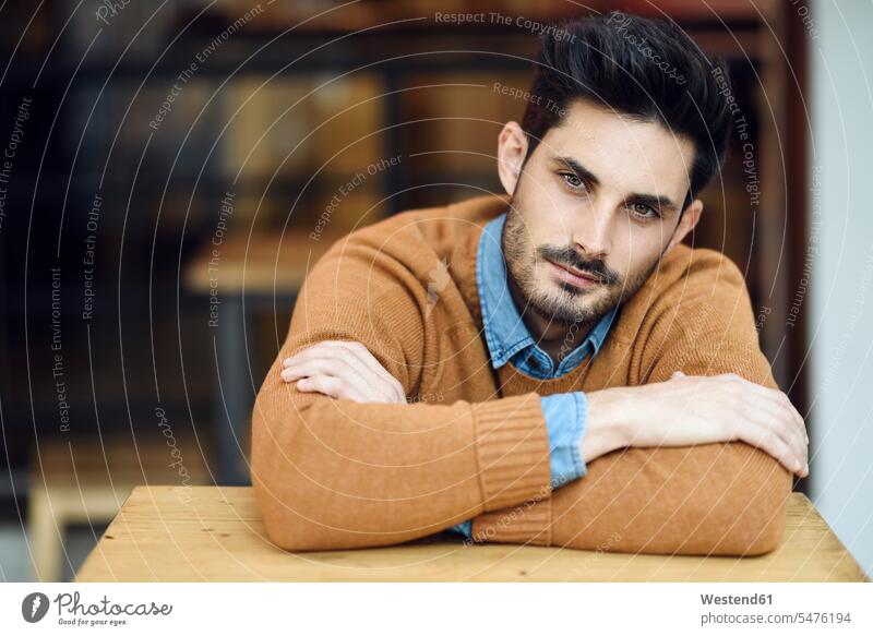 Portrait of young man sitting in a coffee shop portrait portraits cafe waiting men males Adults grown-ups grownups adult people persons human being humans