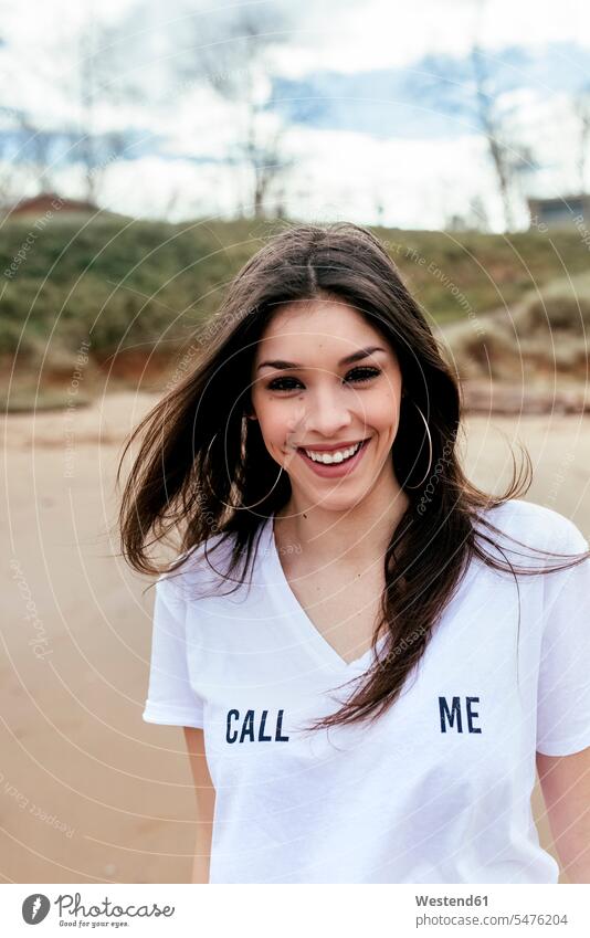 Portrait of a laughing brunette woman on the beach brown hair brown haired brown-haired females women beaches portrait portraits Laughter dark hair dark-haired