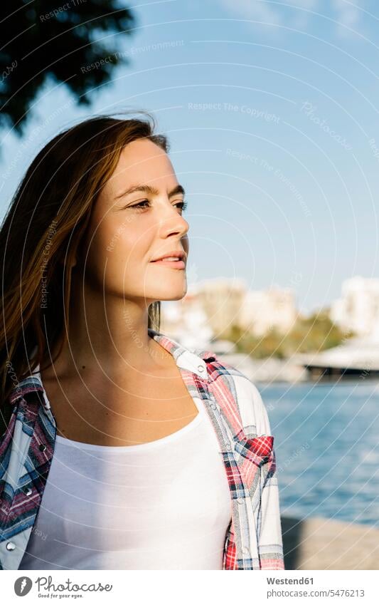 Thoughtful woman looking away while standing at seaside on sunny day color image colour image outdoors location shots outdoor shot outdoor shots daylight shot