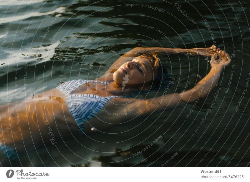 Portrait of woman floating in a lake females women drifting flotation portrait portraits lakes Adults grown-ups grownups adult people persons human being humans