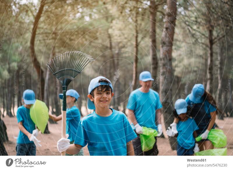 Portrait of a boy with group of people collecting garbage in a park human human being human beings humans person persons caucasian appearance