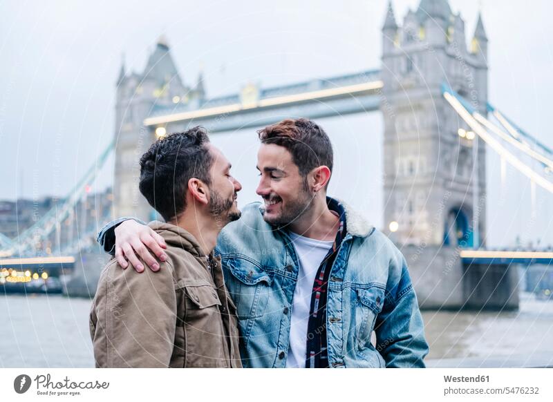 London, United Kingdom, A couple of guys embracing in front of Tower Bridge image picture pictures images photograph photos photographs horizontal