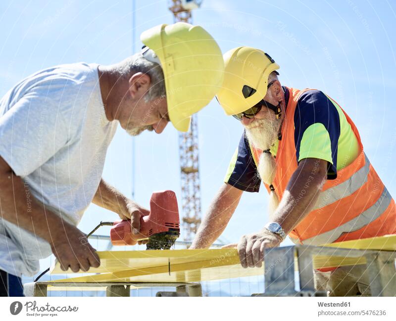 Construction worker cutting plywood with jigsaw on construction site construction worker builders Building Site sites Building Sites construction sites Jigsaw