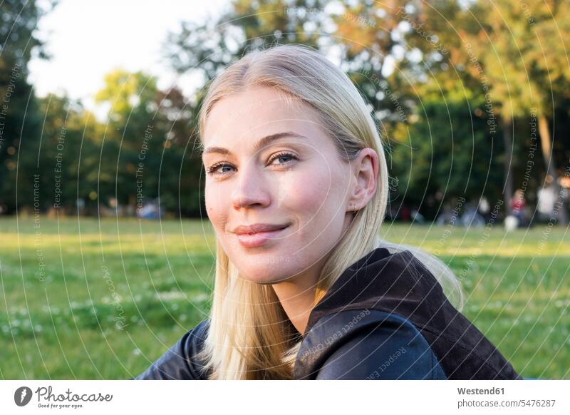 Portrait of content blond woman relaxing in a park portrait portraits females women relaxation blond hair blonde hair parks pleased Adults grown-ups grownups