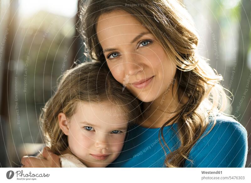 Portrait of smiling mother with daughter in front of window daughters home at home windows portrait portraits mommy mothers ma mummy mama child children family