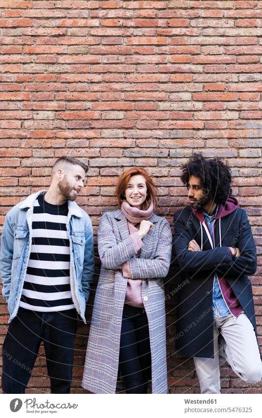 Portrait of three friends standing at a brick wall portrait portraits brick walls friendship fashionable Spain arms crossed Arms Folded Folded Arms Crossed Arms