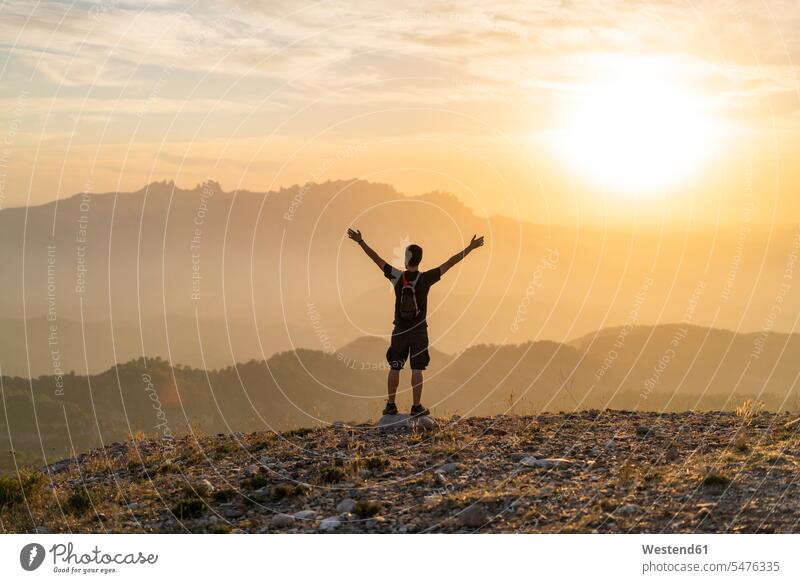 Spain, Barcelona, Natural Park of Sant Llorenc, man hiking and cheering at sunset sunsets sundown jubilation hike men males atmosphere atmospheric mood moody