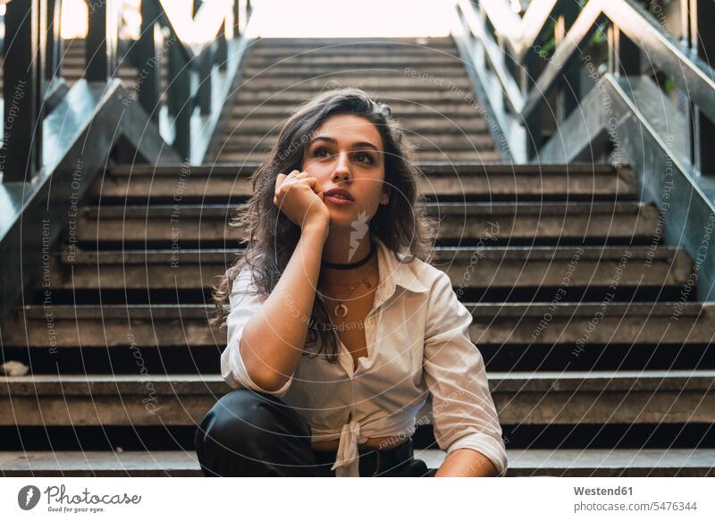 Portrait of young woman sitting on stairs stairway Seated females women portrait portraits Adults grown-ups grownups adult people persons human being humans