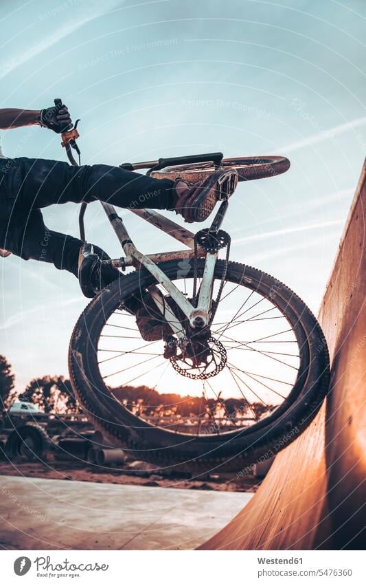 Young man riding bicycle on ramp in park during sunset color image colour image Spain leisure activity leisure activities free time leisure time casual clothing