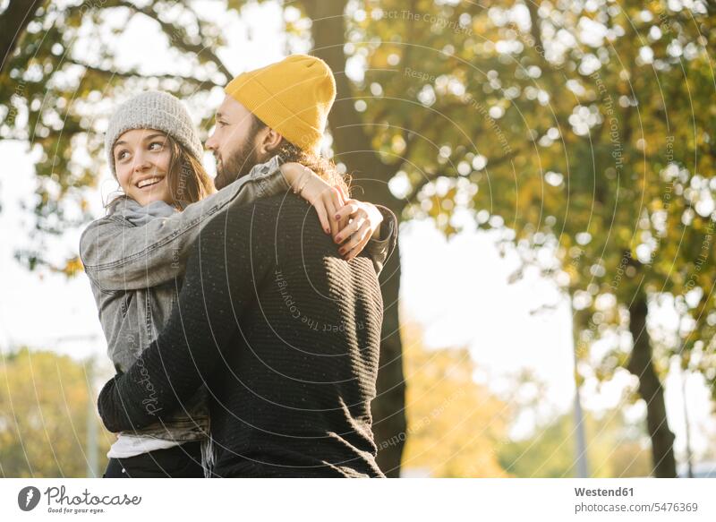 Happy young couple embracing in a city park, Berlin, Germany touristic tourists smile travel traveling embrace Embracement hug hugging seasons fall delight