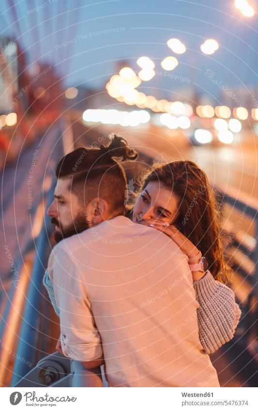 Contemplated couple standing on bridge in city at night color image colour image Moscow Central Russia Russian Federation outdoors location shots outdoor shot