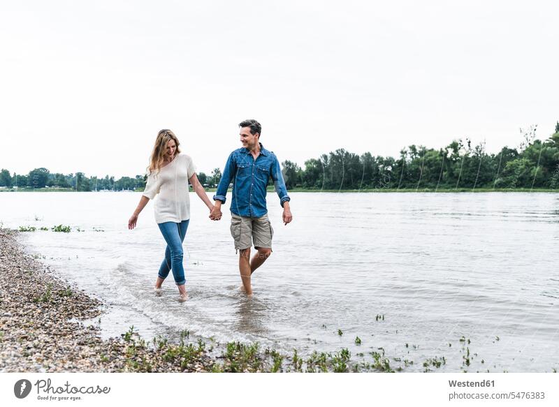 Happy couple wading in river walking going smiling smile River Rivers twosomes partnership couples Wading wade water waters body of water people persons