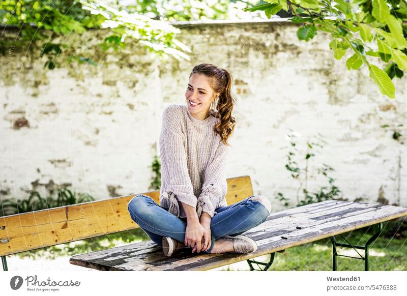 Portrait of smiling woman sitting on beer table at courtyard courtyards courts Beer Table Beer Tables females women smile portrait portraits Seated Adults