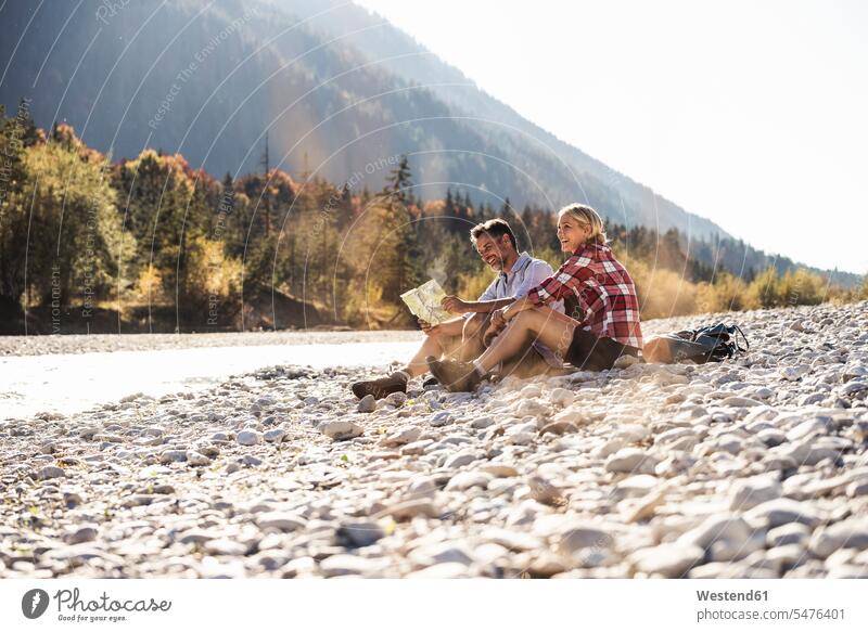 Austria, Alps, couple on a hiking trip having a break at a brook reading map caucasian caucasian appearance caucasian ethnicity european White - Caucasian