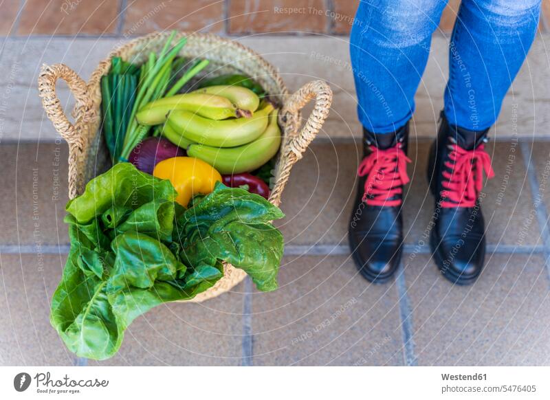 Woman standing by basket full of organic fruit and vegetables human human being human beings humans person persons caucasian appearance caucasian ethnicity