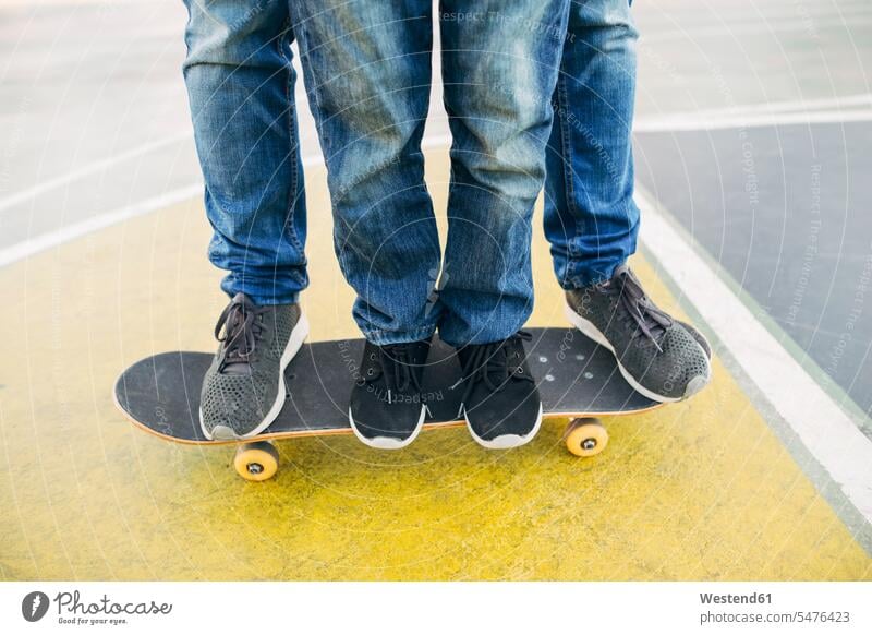 Legs of adult and child on skateboard Adults grown-ups grownups Skate Board skateboards leg legs human leg human legs children kid kids people persons