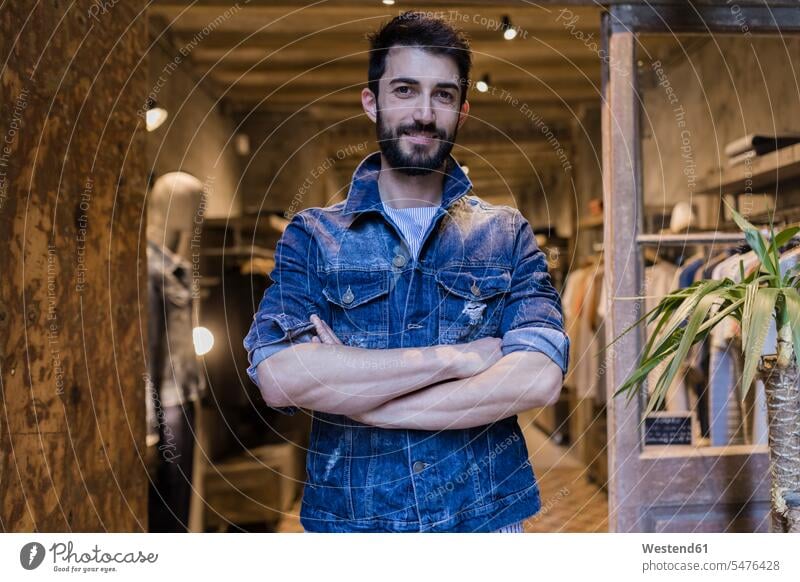 Portrait of smiling man wearing denim jacket in menswear shop customer clientele clients customers men's fashion males portrait portraits modern contemporary