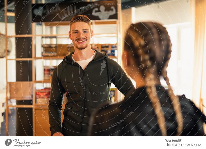 Coach talking to young woman at front desk of a gym human human being human beings humans person persons caucasian appearance caucasian ethnicity european 2