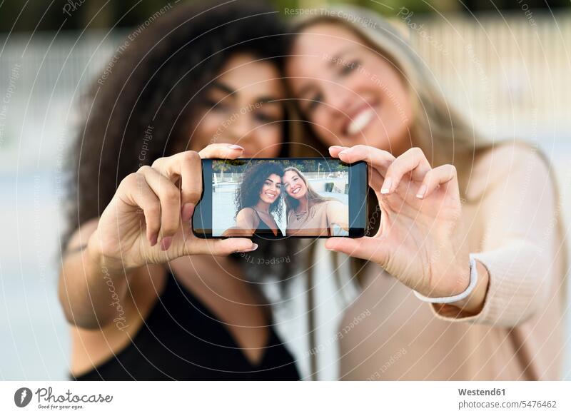 Two friends taking selfie with cell phone, close-up Smartphone iPhone Smartphones Selfie Selfies mobile phone mobiles mobile phones Cellphone cell phones