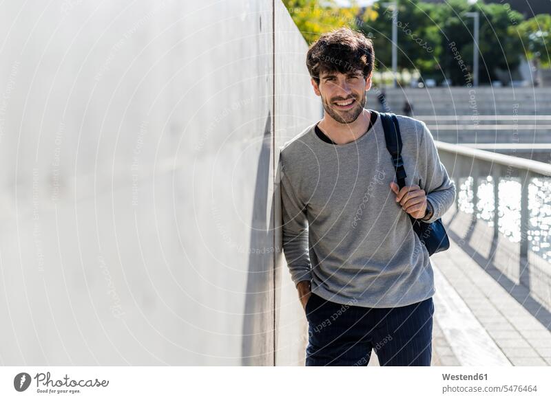 Portrait of smiling man with backpack having a break in the city touristic tourists business life business world business person businesspeople Business man
