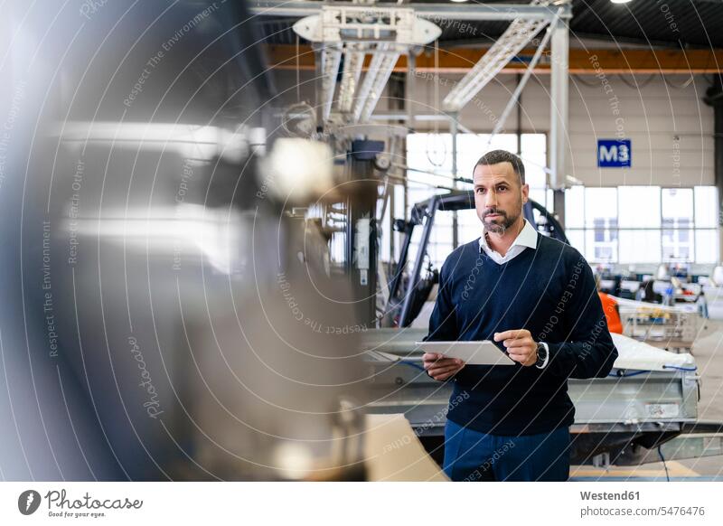 Businessman using tablet in a factory think business life business world business person businesspeople Business man Business men Businessmen economic economics