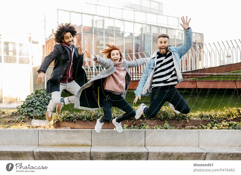 Three happy friends jumping in the city town cities towns happiness Leaping friendship outdoors outdoor shots location shot location shots jumps Vitality Verve