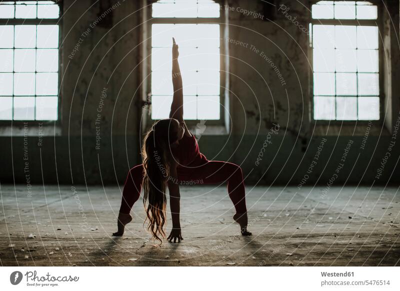 Athlete exercising yoga position at abandoned factory color image colour image indoors indoor shot indoor shots interior interior view Interiors Sportswear