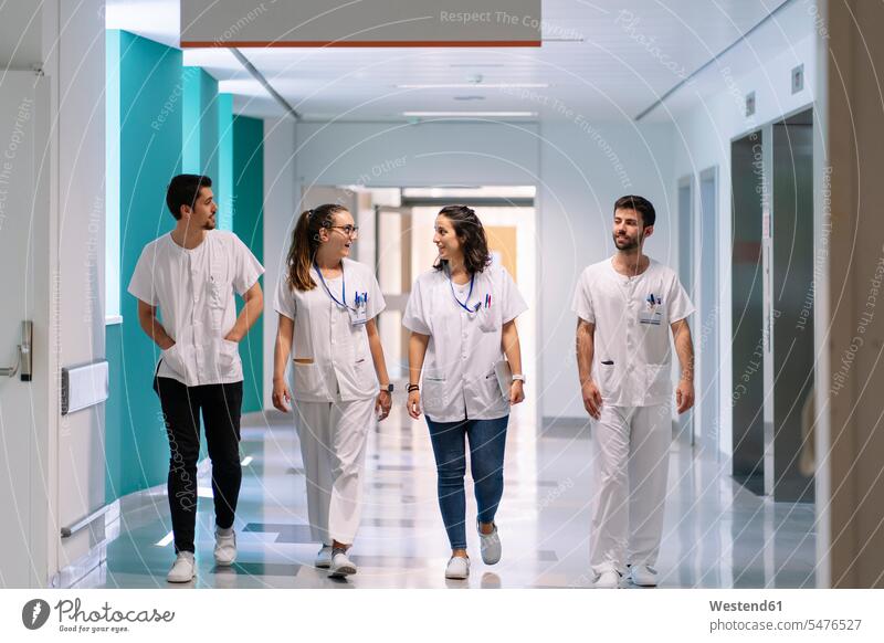 Doctors discussing while walking in corridor at hospital color image colour image Spain indoors indoor shot indoor shots interior interior view Interiors