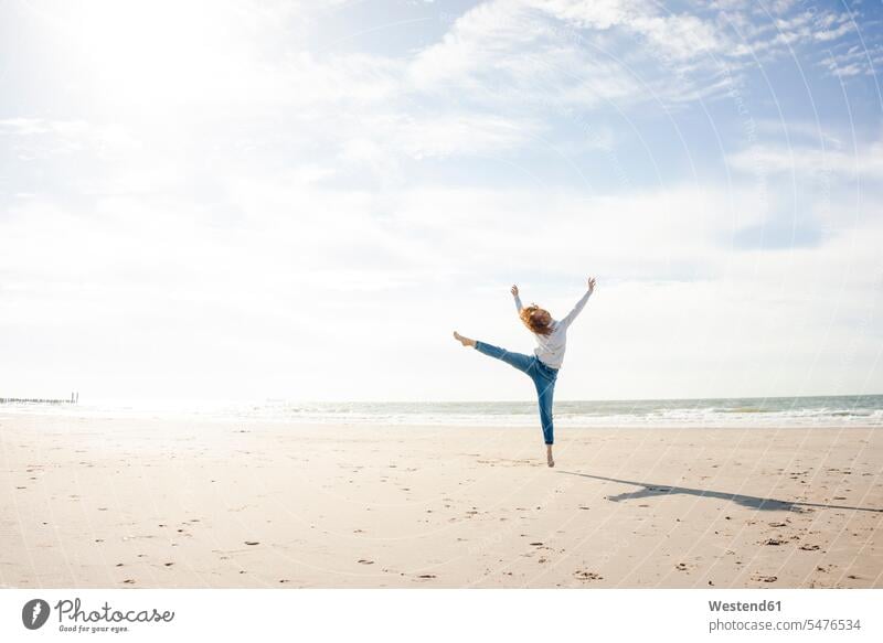 Happy woman having fun at the beach, jumping in the air beaches dancing dance females women Leaping happiness happy Fun funny Adults grown-ups grownups adult