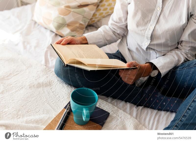 Close-up of woman with book sitting on bed at home human human being human beings humans person persons celibate celibates singles solitary people