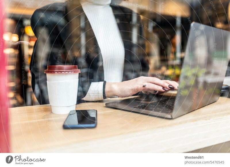 Close-up of businesswoman using laptop at a cafe in the city Occupation Work job jobs profession professional occupation business life business world