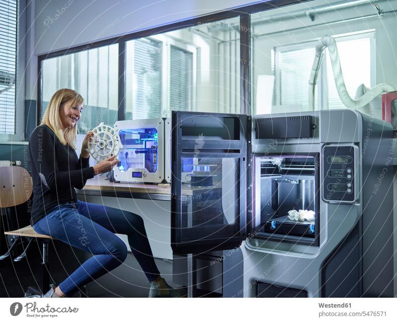 Female technician checking turbine wheel being printed with 3D printer human human being human beings humans person persons caucasian appearance