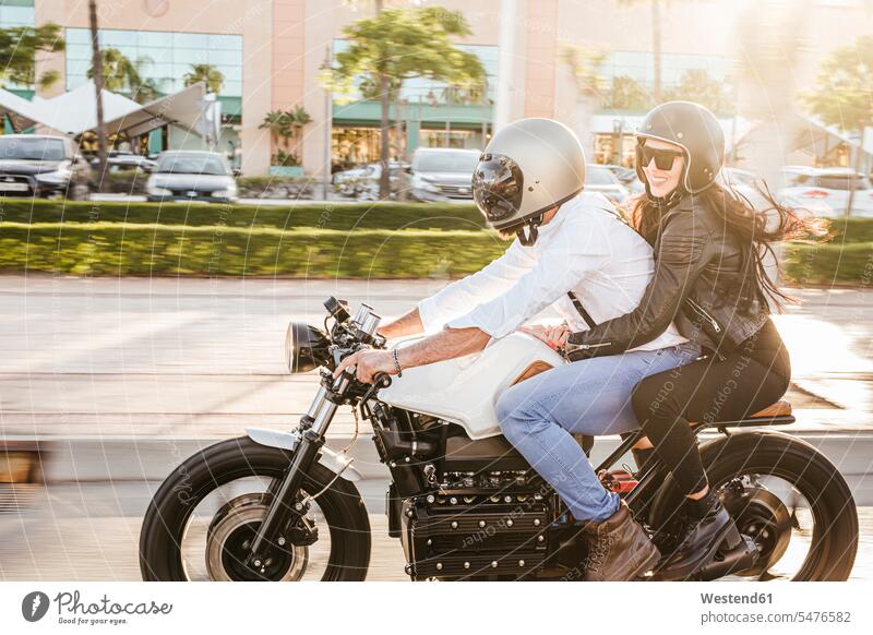 Couple riding motorbike in the city motor vehicles road vehicle road vehicles Motor Cycle motorbikes motorcycle motorcycles Eye Glasses Eyeglasses specs
