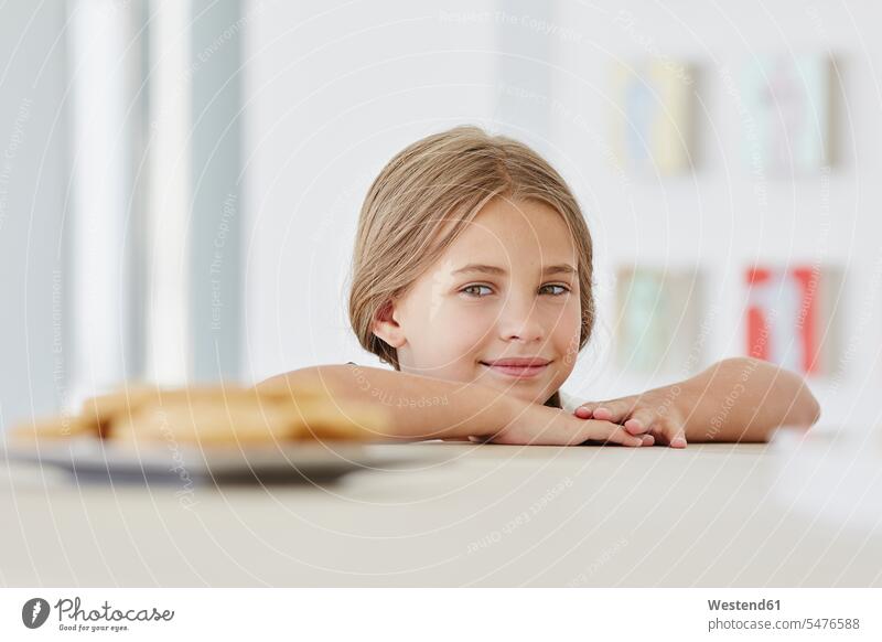 Portrait of a cute girl at home with plate on table heads faces human face human faces dish dishes Plates Tables smile content Contented Emotion pleased Wishes