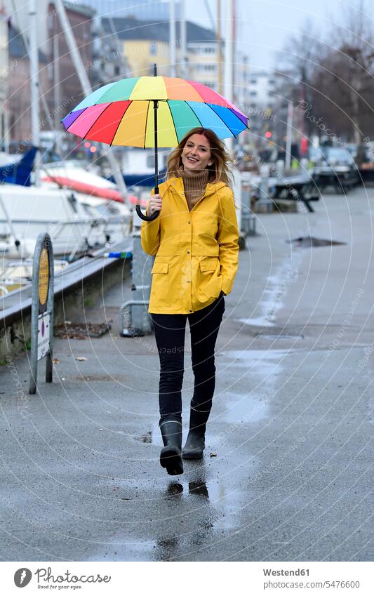 Denmark, Copenhagen, happy woman with colourful umbrella strolling at city harbour multi-coloured multicoloured multi colored Multi Coloured colorful town