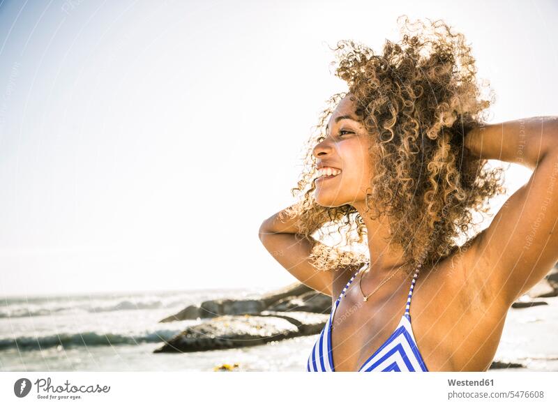 Portait of happy young woman on the beach human human being human beings humans person persons curl curled curls curly hair swim wear bikinis smile seasons